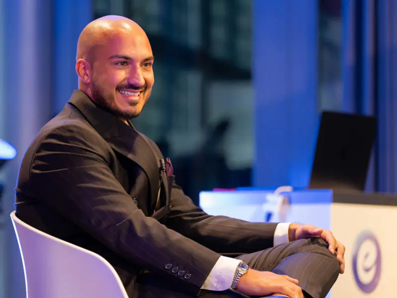 Emin Deniz Saygin lacht auf der Bühne an einem Ecomone-Event